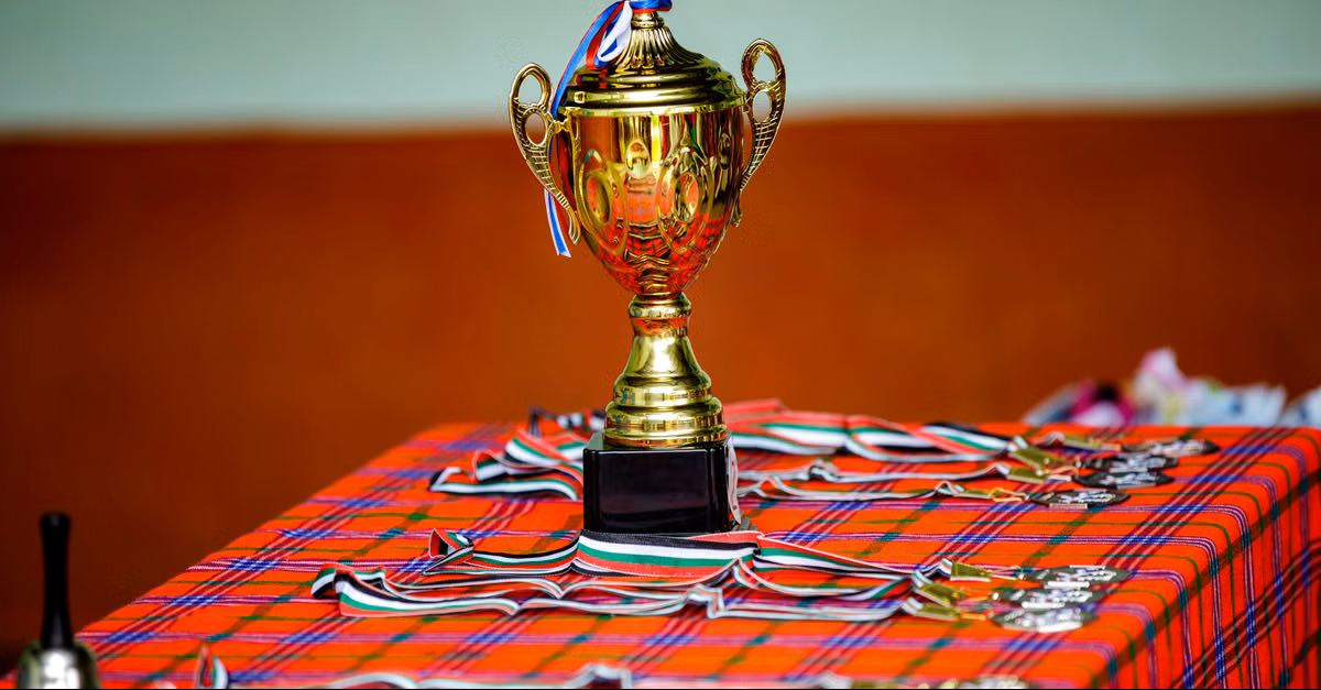 Golden trophy with medals and ribbons representing achievement and rewards